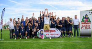 Feiernde Fußballspieler mit Pokal