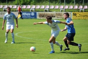 Fußballspieler rennen auf Rasen zum Ball