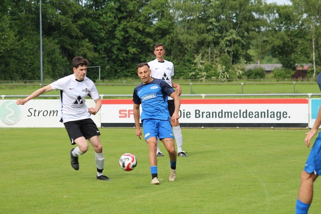 Ball über dem Rasen, Fußballspieler daneben